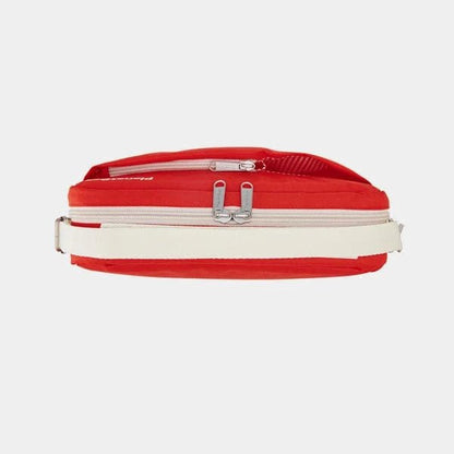 A red waist bag with a wide off-white horizontal stripe and silver zipper hardware, shown against a light gray background.
